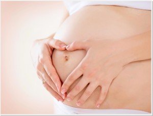 Grávida com a mão na barriga.